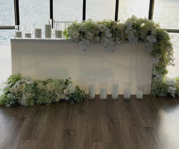 white acrylic table for bridal and event hire styled with babies breath florals and powder candles in Port Melbourne in Melbourne